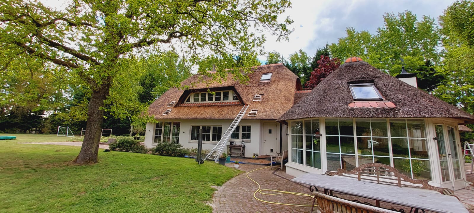 Rieten dak van vrijstaande woning tijdens onderhoud door Alting Rietbeheer